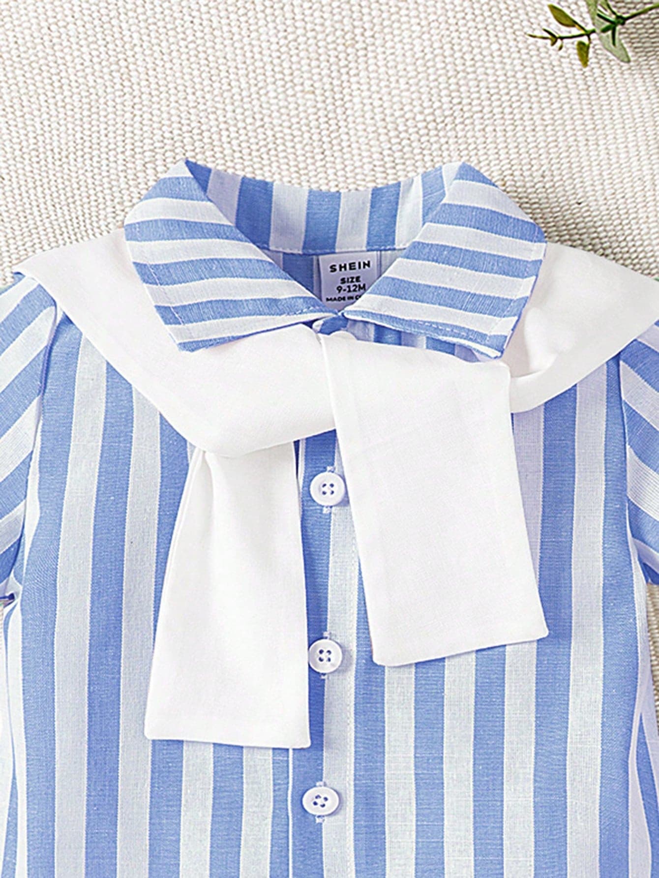 طقم ولادي ذو قميص أزرق مخطط وشورت أبيض ولحشة