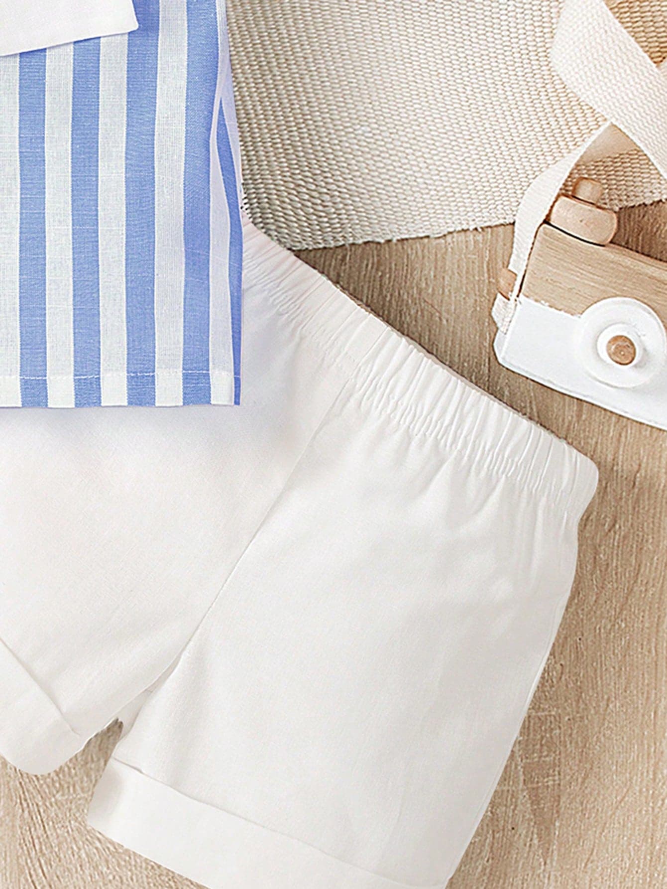 طقم ولادي ذو قميص أزرق مخطط وشورت أبيض ولحشة