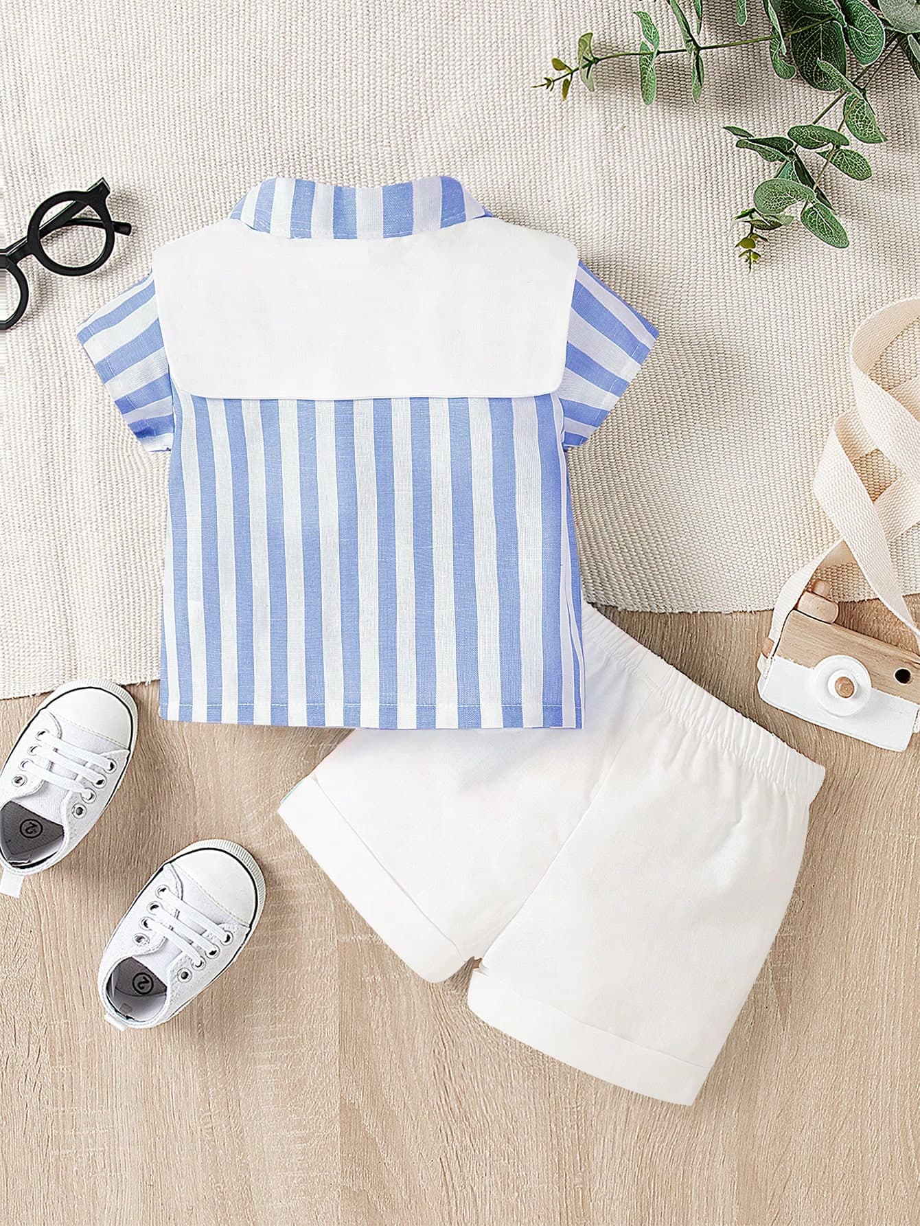 طقم ولادي ذو قميص أزرق مخطط وشورت أبيض ولحشة